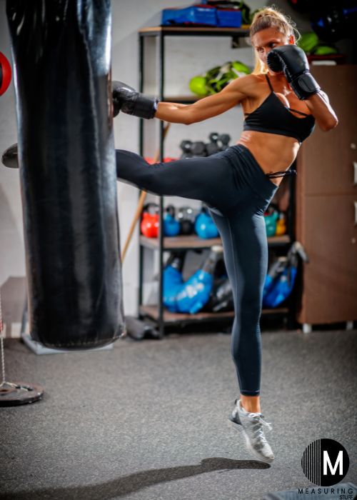 woman kicking a punching bag