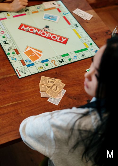woman sitting at Monopoly game table